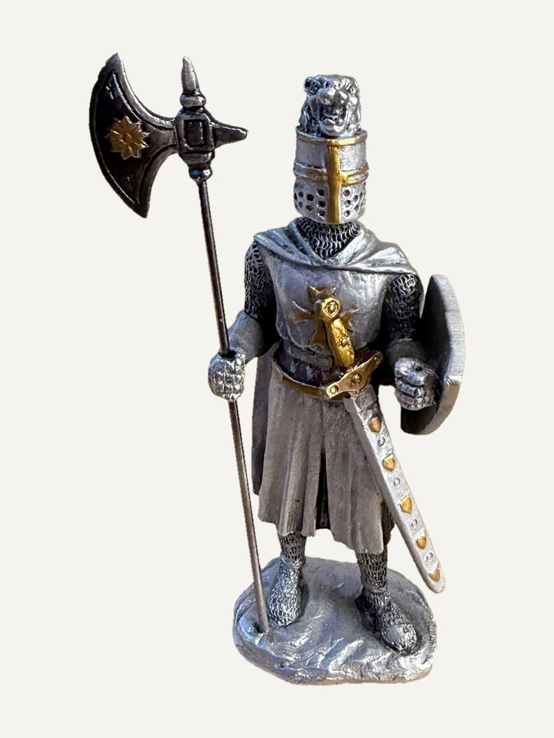 Statuetta in peltro di un cavaliere con l'elmo chiuso sormontato da una testa di leone, un'ascia dal manico lungo in mano, scudo tondo al braccio sinistro, sopravveste segnata da una croce, spada nel fodero