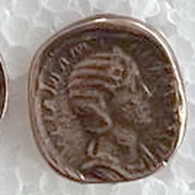 Modern replica of a Roman bronze coin with a woman’s portrait, not identified, the portrait: Bust of a woman facing right, hair in horizontal waves with a bun at the nape; no legible letters. Indicative photo of the replica on sale in the shop, bronze-coloured.