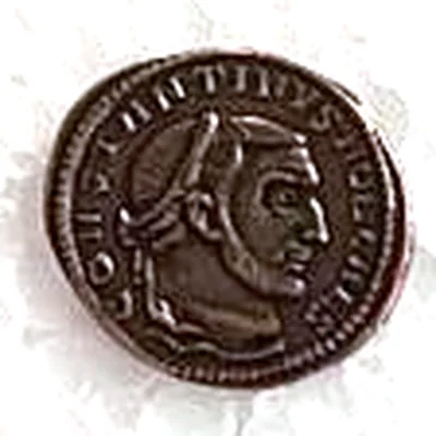 Modern replica of the portrait on a follis of Constantine as Caesar, with a modern side, the portrait: Head of Constantine with a laurel wreath, facing right; around it, CONSTANTINVS NOB CAES. Indicative photo of the replica on sale in the shop, bronze-coloured.