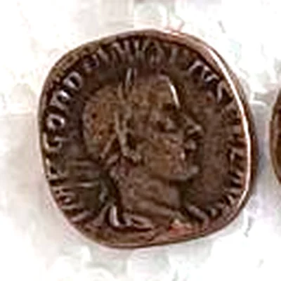 Modern replica of a sestertius of Gordian III, the portrait: Bust of Gordian III with a laurel wreath, drapery and cuirass, facing right; IMP GORDIANVS PIVS FEL AVG can be read. Indicative photo of the replica on sale in the shop, bronze-coloured.