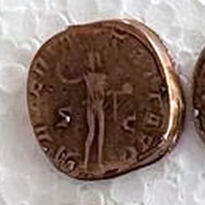Modern replica of a sestertius of Gordian III, the figure raising a hand: A naked man stands raising his right hand; perhaps a globe in his left; S and C on either side. The legend around it cannot be read. Indicative photo of the replica on sale in the shop, bronze-coloured.