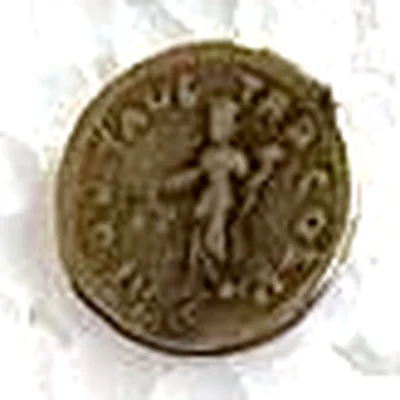 Modern replica of a small Roman coin, not identified, the standing figure: A standing figure holding an object in each hand; around it, uncertain letters: …AVG TR P COS… Indicative photo of the replica on sale in the shop, gold-coloured.