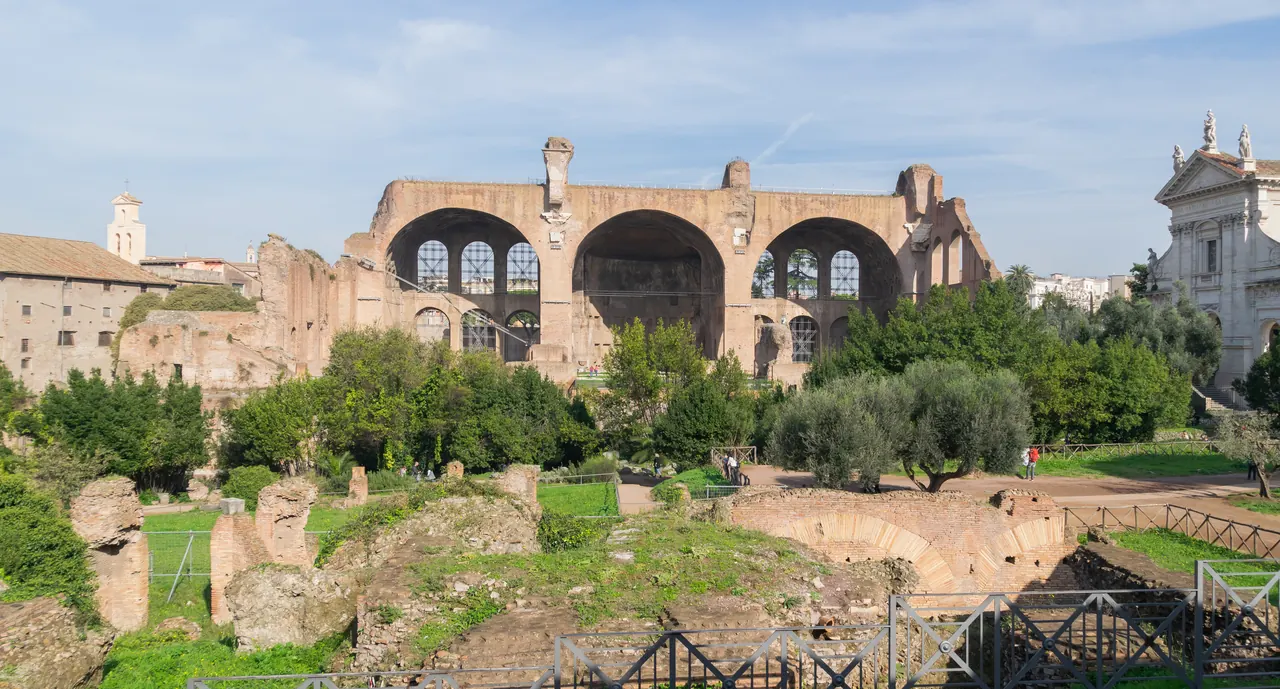 The three coffered vaults of the Basilica of Maxentius against a blue sky.
