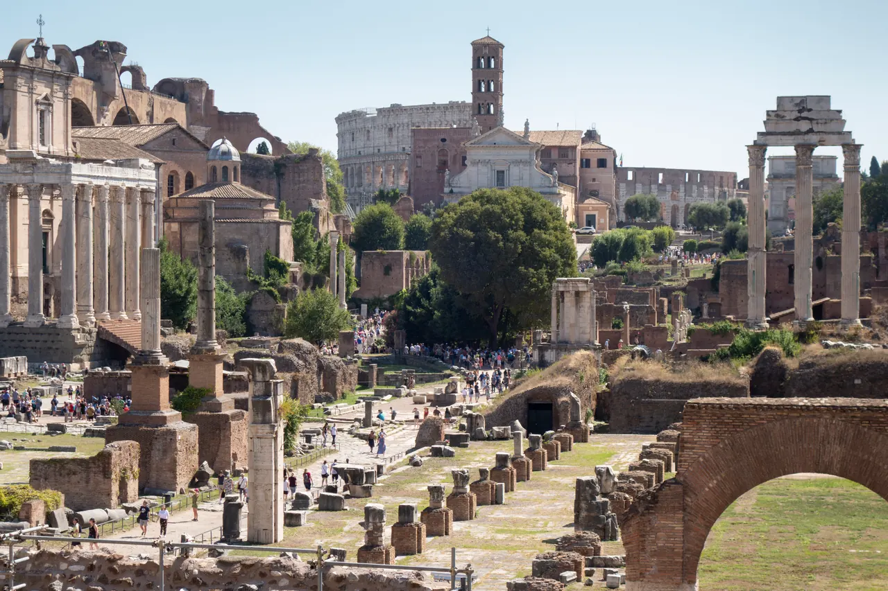 The Roman Forum looking east: ruins, columns and the Colosseum in the distance.