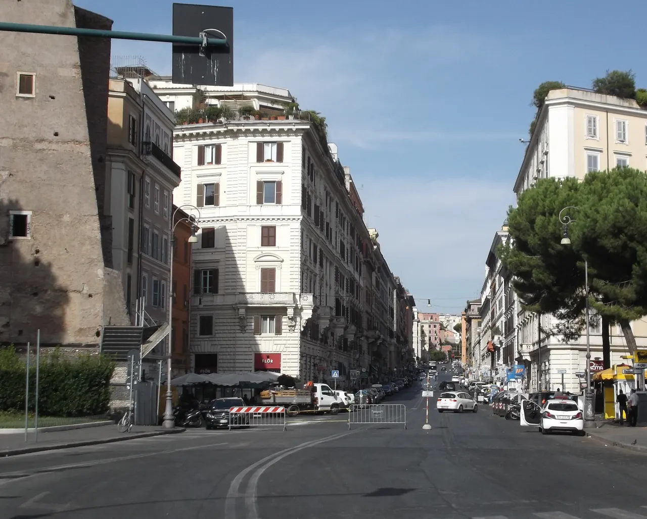 Via Cavour climbing from Largo Corrado Ricci between nineteenth-century buildings.