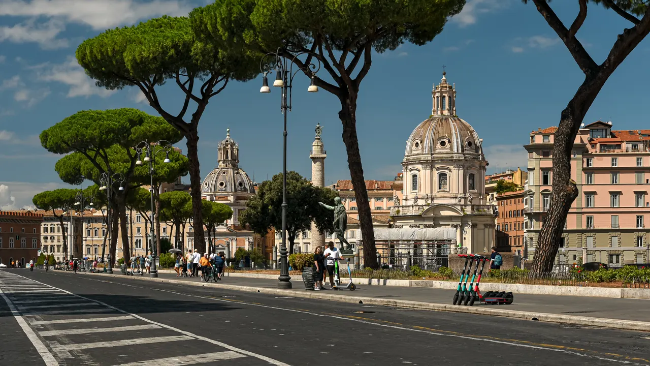 Via dei Fori Imperiali towards Piazza Venezia: pines, street lamps and, at the end, the domes of the churches by Trajan's Forum.